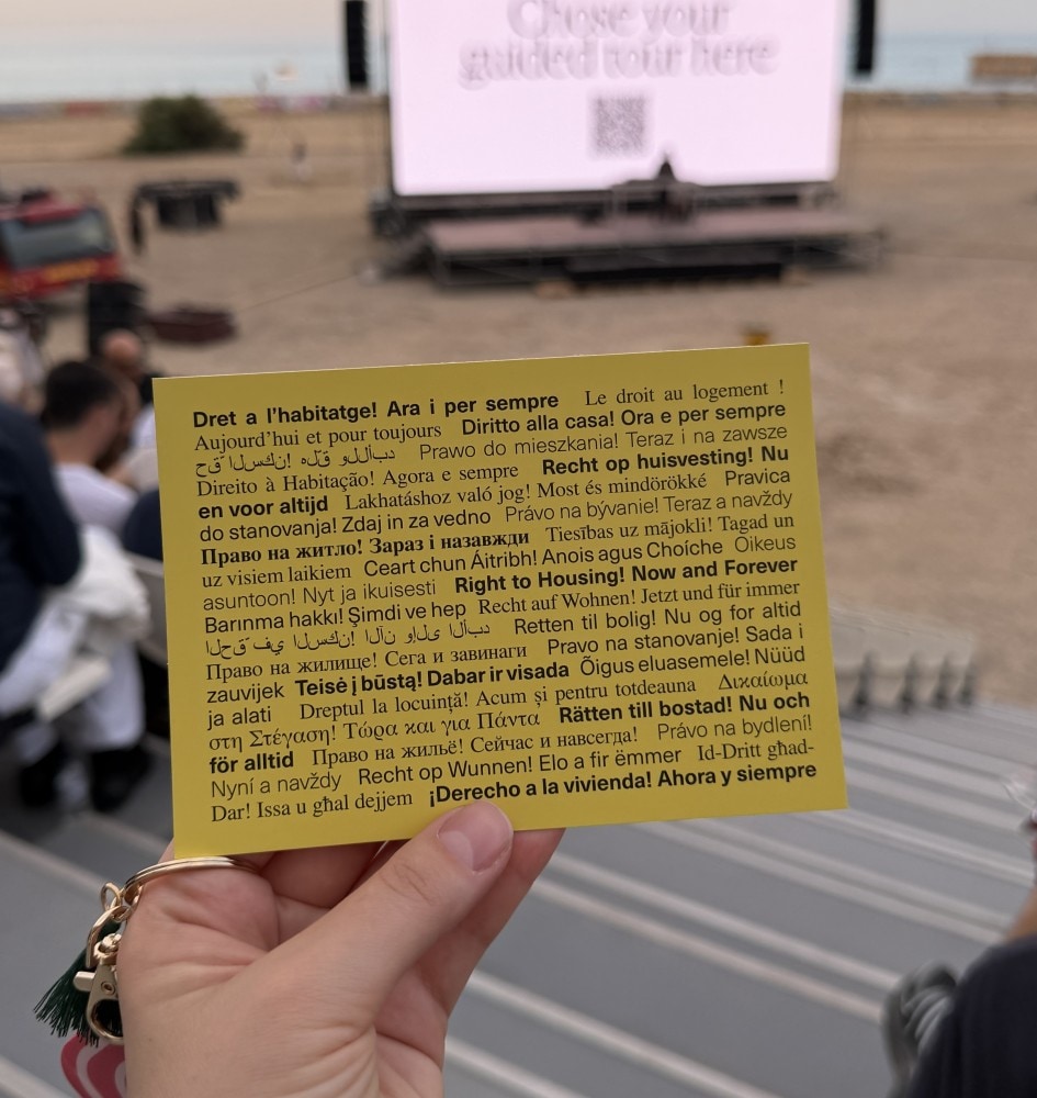 Congress attendee holding a yellow card printed with a statement about place and belonging.